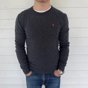 Mörkgrå stickad tröja från Morris - Säljer denna mörkgrå stickad tröja från Morris i 100% merinoull. Endast för 399!Tröjan har ett diskret kabelstickat mönster. Tröjan är i storlek M men sitter som S.