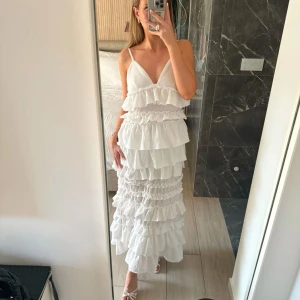 Vit långklänning med volanger - Säljer världens finaste studentklänning!!🫶🏼🫶🏼 Kan skicka samma dag om du klickar på köp direkt. Klänningen är aldrig använd o har prislapparna kvar. Wow wow wow