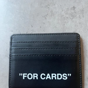 Korthållare, egen design med Off White inspo - Korthållare/cardholder med texten ”FOR CARDS” framtill. Finns i både svart och grått, tillverkat i slätt skinn med flera kortfack. Sammanlagt 3st kortfack och ett stort för sedlar etc i toppen. Perfekt för att hålla ordning på dina kort i stilren design och även den nya trenden med korthållare som du kan bära med dig i vilka byxor, shorts, väskor eller egentligen vilken ficka som helst. Begränsad upplaga då jag själv designar så vid önskan kan man välja text själv! Inspiration från Off White.