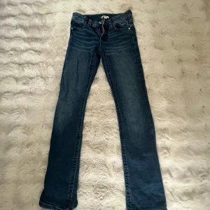 Mörkblå jeansbyxor med raka ben - Säljer ett par mörk blåa bootcut jeans, som är low waist men kanske inte ser ut som de på bilden, är 166 och storleken på jeansen är 164 och sitter jätte bra men kommer inte heller till användning. 