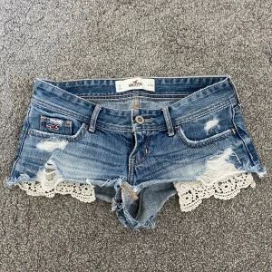 Jeansshorts med spets - Supersnygga jeansshorts  från Hollister med låg midja, slitna detaljer och en vit spetskant nedtill. Spetsen är enkel att vika om man föredrar det! Tyvärr inga bilder på då jag inte får på mig dem!🥰