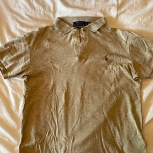Beige pikétröja från Polo Ralph Lauren - Säljer en beige pikétröja från Polo Ralph Lauren i slim fit-modell. Tröjan är i 100% bomull och är använd en gång. Storlek S men passar XS.