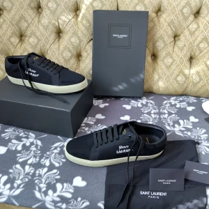 Svarta sneakers från Saint Laurent - Feta svarta sneakers från Saint Laurent med beige sula och svart top. Skorna har klassisk snörning och är tillverkade i en mix av skinn och textil. Perfekta för dig som gillar stilrena och exklusiva sneakers.