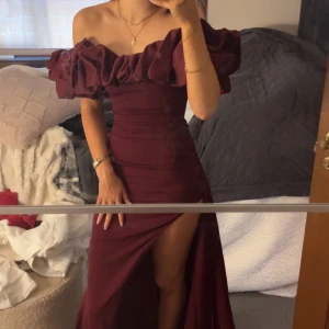 babyboo klänning - Säljer en vinröd långklänning med offshoulder och stora volangdetaljer upptill. Jag hade bal i förrgår men denna klänningen kom idag så den är helt oanvänd. nypris ink tull och frakt: närmare 3000 kr