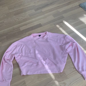 Ljusrosa croppad sweatshirt - Säljer en ljusrosa croppad sweatshirt . Tröjan har rund hals, långa ärmar och är tillverkad i mjuk bomull. Perfekt för dig som gillar en chill och trendig stil. Passar dig som vill ha en enkel men snygg look.
