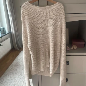Oversized beige stickad tröja - Säljer en oversized stickad tröja i beige med grov struktur och bred halsringning. Tröjan har långa ärmar och en avslappnad passform som är perfekt för lager-på-lager. Materialet känns mjukt och är stickat i ett klassiskt mönster. Passar dig som gillar chill och comfy vibes.