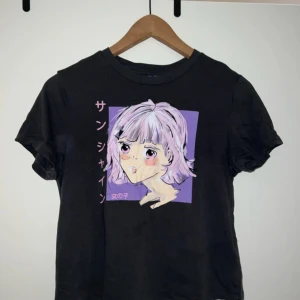Mörk grå anime t-shirt - Mörk grå T-shirt med anime/manga motiv. Ljuset gör så den ser svart ut & som en fläck till vänster. Tröjan är fläckfri på synliga ställen, endast lite deodorant på insidan. 