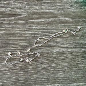 Silverfärgat halsband med fjärilar - Säljer ett tunt och stilrent halsband i silverfärg med små fjärilar som detaljer längs kedjan. Perfekt för dig som gillar minimalistiska smycken med en söt touch. Justerbar längd med flera öglor för att passa olika stilar.