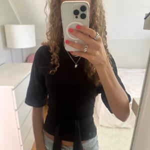 Svart knyt T-shirt Nelly - Otroligt snygg T-shirt med knyt rygg ifrån Nelly!🥰 Går att knyta på flera sätt, storlek xs men passar även xxs/s💕💕