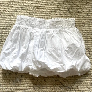 Vit kortkjol med smock och volang - Supersöt vit ”ballon skirt” som passar perfekt på sommaren eller till ett par strumpbyxor!💞
