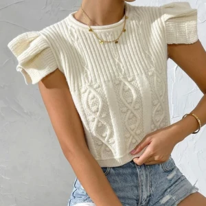 Vit stickad tröja med puffärm från Gnefit - Supersöt vit stickad tröja från Gnefit med korta puffärmar och coolt kabelstickat mönster framtill. Tröjan har rund hals och ribbade detaljer som ger en trendig vibe. Perfekt att matcha med jeans eller kjol för en chill look.