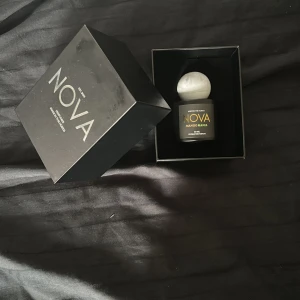 NOVA Mango Mania parfym 50ml - NOVA Mango Mania är en exklusiv parfym i en stilren svart flaska med en unik marmorerad vit rund kork. Flaskan rymmer 50 ml extrait de parfum och levereras i en elegant svart ask med silverdetaljer. Doften har tropiska inslag av mango och modern design.