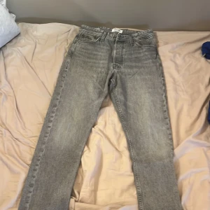 Grå loose fit jeans Jack & Jones storlek 27 &30 - Säljer ett par grå loose fit jeans från Jack & Jones, modell Chris. Jeansen har klassisk femficksdesign, raka ben och snygg tvättad look. Perfekta för dig som gillar en avslappnad stil och vill ha bekväma jeans med lite bredare passform.