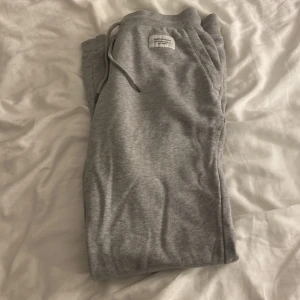 Grå mjukisbyxor Peak Performance S - Grå mjukisbyxor från Peak Performance i storlek S. Byxorna har dragsko i midjan, muddar vid bensluten och två sidofickor. Perfekta för chill dagar eller när du vill vara extra bekväm. Klassisk och enkel design i mjukt bomullsmaterial.