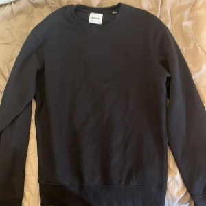 Svart sweatshirt från Jack & Jones storlek S - En stilren svart sweatshirt från Jack & Jones med rund halsringning och långa ärmar. Tröjan är i mjuk bomull och har en klassisk passform som funkar till det mesta. Perfekt för dig som gillar enkel och clean stil.