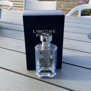Prada L'Homme Pour Homme parfym - Fräsch och stilren herrparfym från Prada, L'Homme Pour Homme. Flaskan är transparent med silverfärgat lock och blå detaljer på sidorna. Kommer i elegant svart kartong med silvrig text. Perfekt för dig som gillar exklusiva dofter. Nypris 1050kr 35- 40 ml kvar