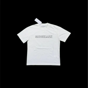 Maison Margiela T-shirt  - Vit t-shirt från Maison Margiela med klassisk passform och svart textprint på bröstet. Tillverkad i mjuk bomull och har rund halsringning samt korta ärmar. Enkel och stilren design som passar till allt.