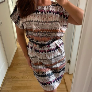 Mönstrad klänning - Mönstrad knälång klänning med knytband i strl M o fint skick, förutom att en söm rispats upp lite (se sista bilden) 💌 