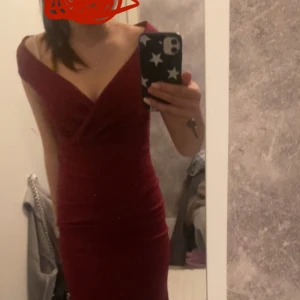 Vinröd långklänning från Goddiva - hej! jag säljer nu min balklänning från bubbleroom då den inte kommer att komma till användning. Klänningen är endast använd en gång och i helt nytt skick! nypris 999kr. Klänningen har omlott-drapering framtill, djup v-ringning och offshoulder-design. Materialet är mjukt och följsamt, med dragkedja i ryggen för enkel påklädning. Perfekt för dig som vill sticka ut med stil.