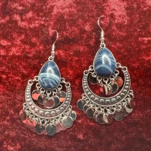 Bohoörhängen med marmorerad blå sten & silverhängen - Retro Hippie Vibe- Nya & oanvända  -  Bohemiska örhängen med droppformad blå dekorsten och detaljer i silverfärgad metall. Den halvmåneformade ramen är dekorerad med små blanka berlocker som rör sig vackert när du bär dem. Perfekta för dig som gillar etnisk stil, vintagetouch eller alternativ mode. Lätta och bekväma att bära hela dagen. Mått: ca 6,5 cm. Priset är redan lågt, så jag prutar inte. Men jag ger rabatt vid köp av flera saker så kolla gärna på mina andra annonser!