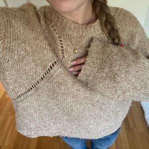 Beige stickad tröja med håldetaljer - Säljer en mysig beige stickad tröja med snygga håldetaljer längs axlarna🥰