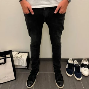 Svarta Replay Anbass jeans skinny fit - Säljer ett par svarta Replay Anbass jeans med skinny passform. Jeansen har klassisk femficksdesign, dragkedjegylf och är tillverkade i stretchig bomullsdenim för en tajt och bekväm känsla. Perfekta för dig som gillar en modern och stilren look. Gylfen funkar ej