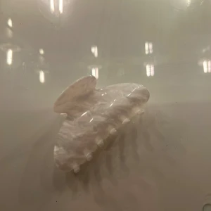 Vit hårklämma med marmormönster - Snygg vit hårklämma med marmorerad finish som ger en fräsch och trendig look. Perfekt för att snabbt sätta upp håret och få till en stilren vibe. Klämman har en mjuk rundad form och starka greppande tänder.