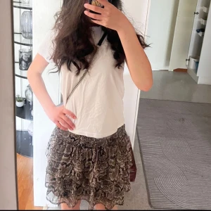 Brun och svart kjol med ormmönster från Ü - Säljer en kort kjol med volanger och elastisk midja från Ü. Kjolen har ett coolt ormmönster i bruna och svarta toner och är perfekt för dig som vill sticka ut. Lätt och luftig modell som ger en trendig look.väldigt finnt och fräscht för sommaren🥂🥂🏖️