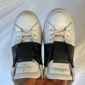 Valentino sneakers med svart detalj - Säljer mina vita Valentino Garavani sneakers med svart läderdetalj. Sparsamt använda och därav i fint skick! Dustbag och äkthetsbevis medföljer. Hör av dig för fler bilder💕