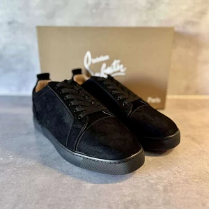 Svarta sneakers från Christian Louboutin - Säljer ett par svarta sneakers från Christian Louboutin i mocka med klassisk röd sula. Skorna har rund tå, svarta snören och diskret logga på sulan. Perfekta för dig som vill ha en stilren och lyxig look.
