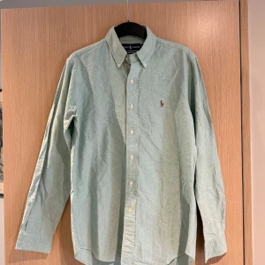 Ljusgrön skjorta från Ralph Lauren - Säljer en ljusgrön skjorta från Ralph Lauren. Måttet är ca 78cm långt och bredden är 59cm lång. Storleken är ca L och skicket är bra om ni stryker den kommer den se som ny ut🤩 Nypris cirka 1600kr 