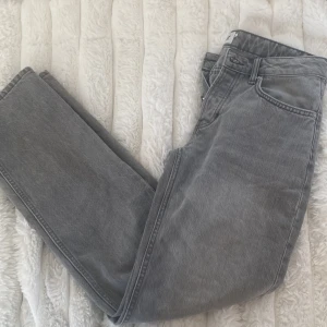 Grå jeansbyxor från lager 157 - Säljer ett par grå jeansbyxor från 157 med raka ben, låg/medelhög midja och knappgylf. Byxorna har en liten fläck på det nedre högra benet. Tidlös modell som passar till mycket.🩵