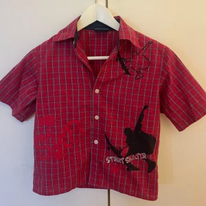 Röd rutig kortärmad skjorta från NOW - Röd kortärmad skjorta från NOW med rutigt mönster i blått och vitt. Sitter Som en storlek S. Hyfsat tight passform. Använd ett fåtal gånger.