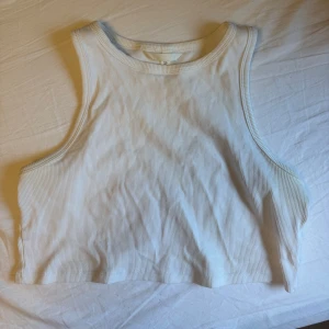 💘🤍Vit ribbad croppad topp från H&M - Säljer en vit ribbad croppad topp från H&M. Superfin att ha under skjorta eller att träna i🤍🤍 Bra basplagg att ha😋