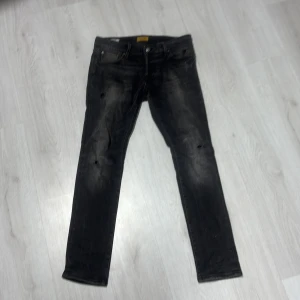 Svarta slim jeans från Jack & Jones - Säljer ett par svarta slim fit jeans från Jack & Jones, modell Slim Glenn. Jeansen har en något tvättad look och klassisk femficksdesign. Perfekta för dig som gillar en smal passform och stilren look.    Dom säljs inte längre hos Jack and Jones !!!