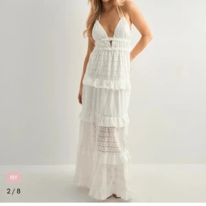 Vit långklänning med volanger och broderade detaljer - Superfin vit långklänning med smala axelband, v-ringning och flera lager volanger. Ordinarie pris- 799kr, endast använt en dag är som ny.🩷