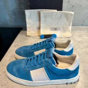 Valentino Flycrew - Snygga sneakers i blå mocka med vita paneler och vit sula. Skorna har rund tå, platt sula och klassisk snörning. Perfekta för en avslappnad och trendig stil. Valentino Flycrew