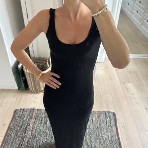 Svart långklänning från Boohoo - Säljer en svart långklänning från Boohoo med djup rundad urringning och breda axelband. Jag är 172 och klänningen går ner till fötterna!Klänningen har en tight passform och är tillverkad i ett mjukt, stretchigt material💕