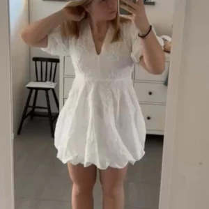 Vit kortklänning med broderade detaljer - Superfin vit kortklänning med v-ringning och broderade blommor. Perfekt till student eller sommarens festligheter. Aldrig använd då jag hitta en annan jag ville ha istället🫶🏼 skriv om ni vill ha bättre bilder eller kolla i min profil för den är samma klänning men i en storlek större!