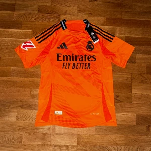 Real Madrid fotbollströja  - Säljer en orange Real Madrid 2024/25 fotbollströja - VINI JR 7 , helt oanvänd!