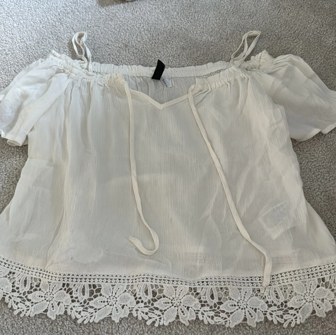 Vit blus med spetsdetaljer från H&M