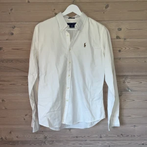 Vit skjorta från Ralph Lauren - Stilren och klassisk vit skjorta från Ralph Lauren i mycket bra skick. Storleken är     S-M men jag skulle säga att den sitter som S. 