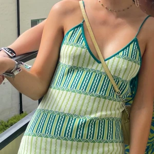 Kort grön klänning  - Grön klänning som använts på festival en gång. Kan även användas i sommar på strand/fest eller liknande. Supersmickrande urringning och ryggdetalj med snörning