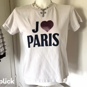 Vit t-shirt med tryck 'J ♥ PARIS' - Klassisk passform och rund halsringning. Perfekt för dig som älskar Paris och vill ha en enkel men snygg statement-t-shirt.