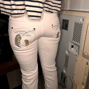 Jeans - Snygga vita jeans med unika broderade detaljer i guld och svart på bakfickorna. De har en klassisk femficksdesign och knäppning fram. Finns bild på alla mått, dom är lite för korta på mig som är 170❤️