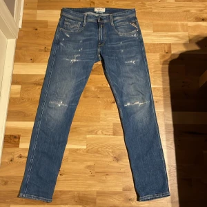 Blå Replay jeans med slitningar - Snygga blå jeans från Replay med en klassisk femficksdesign och slitna detaljer. Nästan helt oanvända/använda några gånger. Ny pris ligger på runt 1800kr. Storlek 32W och 32L. Passtorlek är ganska slim och passar någon runt 180. Skriv för frågor:) pris inte huggit i sten