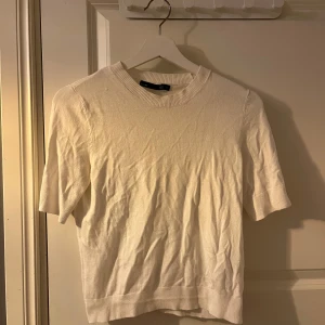 Vit tröja från lager 157 - Säljer en stilren vit tröja från lager157. Tröjan har korta ärmar och en rund halsringning. Perfekt för en minimalistisk look. Passar bra till både jeans och kjol.