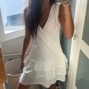 Vit omlottklänning med volanger - Säljer en söt vit omlottklänning med volanger. Passar strl XS-S. Aldrig använd, första bilden är lånad från förra ägaren !!💕💕