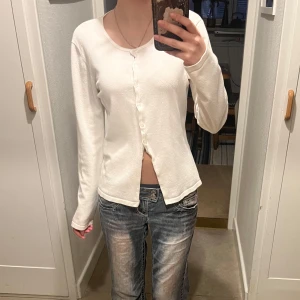 Vit kofta från Saint Tropez - Säljer en stilren vit kofta. Den har långa ärmar och knappar framtill. Perfekt för en enkel och klassisk look. Passar bra till jeans eller kjol.