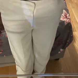 Vita  kostymbyxor - Snygga Vita kostymbyxor med hög midja och rak passform. Perfekta för en stilren look. Byxorna har en diskret dragkedja framtill och är tillverkade i ett bekvämt material.